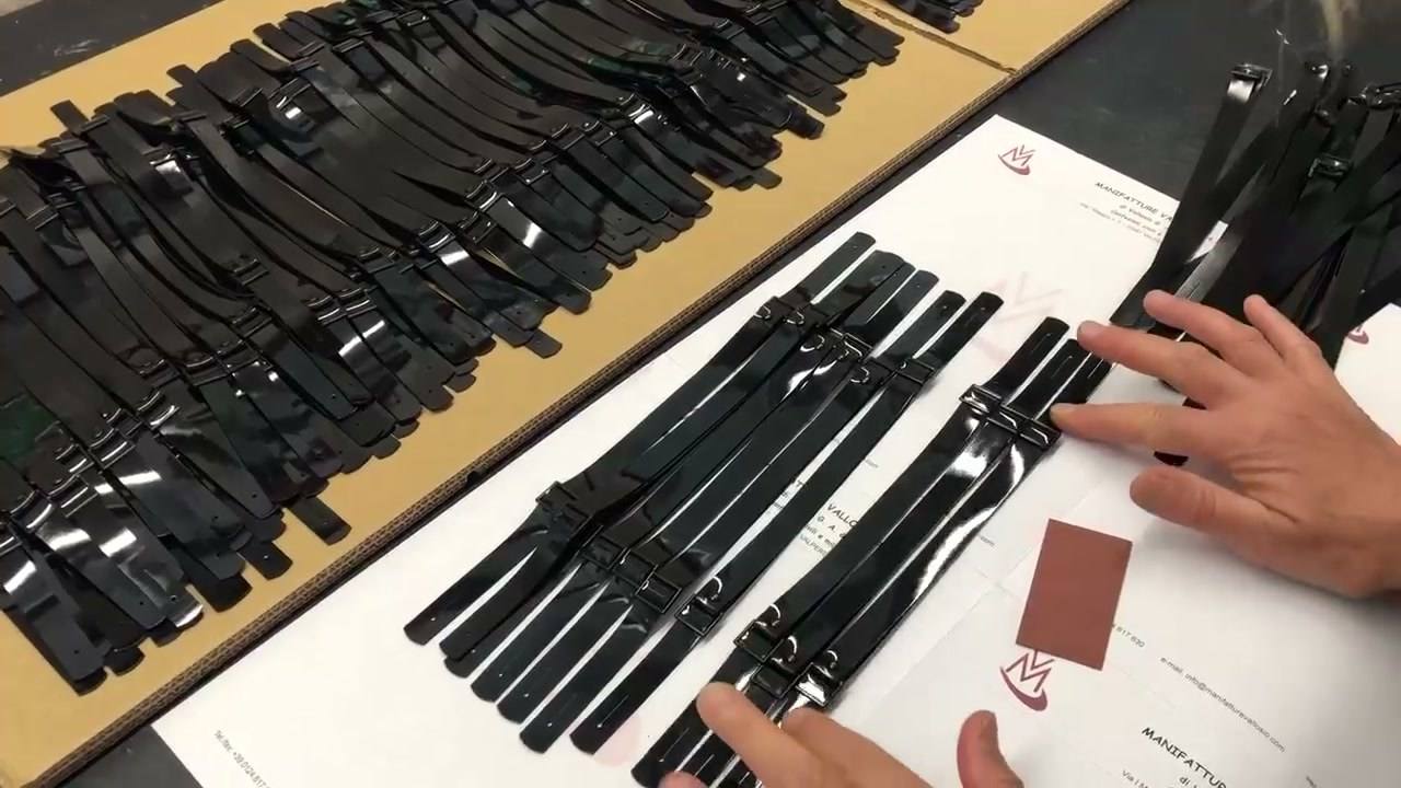 Soggoli in vernice nera allineati sul banco e controllati a mano